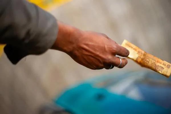 Spectator passing money to a performer