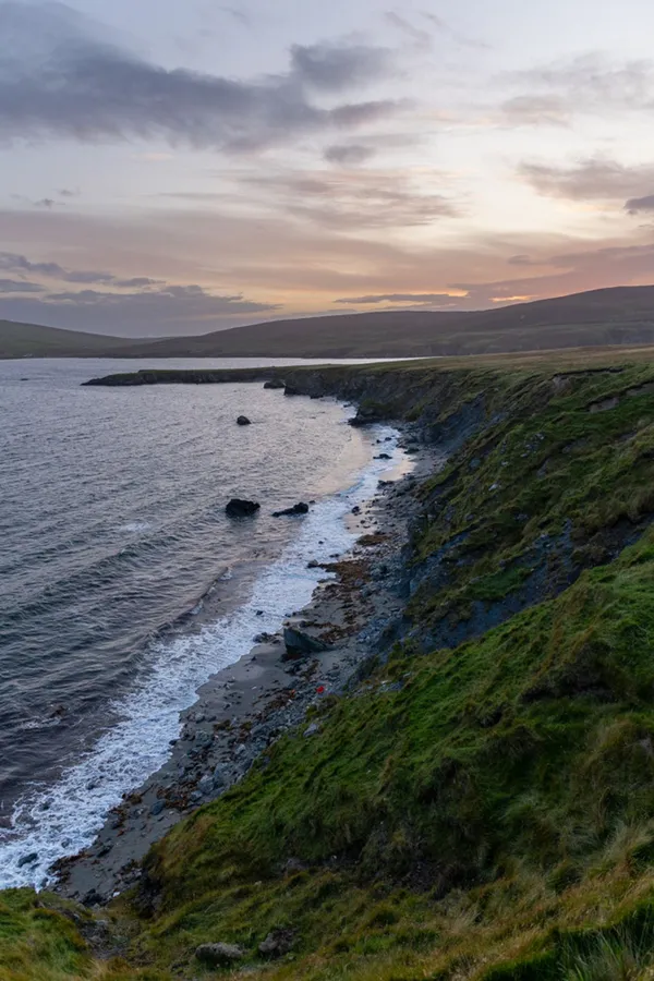 A beach below the cliffs at sunset